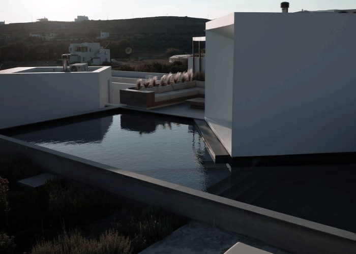 DesignBoom - Perched on the sun-drenched island of Tinos, Greece, Pnoes by Aristides Dallas Architects is a design-forward retreat on the Cycladic island. This cluster of villas, equipped with private pools and gardens, channels the primal elements of earth, wind, and water of the island to create a multisensory experience of relaxation and renewal.
